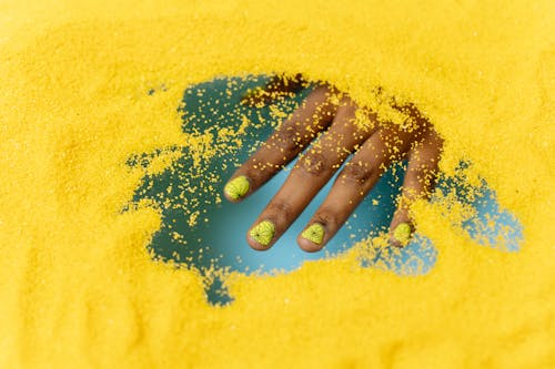 Pessoa Com Manicure Verde Em Tecido Amarelo