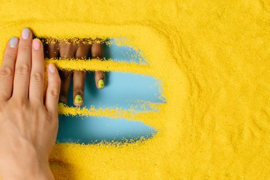 Persons Hand on Yellow Textile