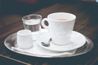 精致的咖啡摆放在金属托盘上，配有浓缩咖啡、水和奶油