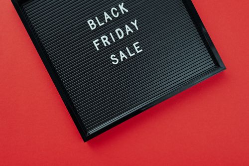 Free Black Friday sale sign on bold red surface, perfect for promotions. Stock Photo