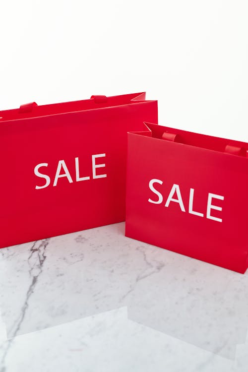 Free Close-Up Shot of Red Shopping Bags on a Marble Surface Stock Photo
