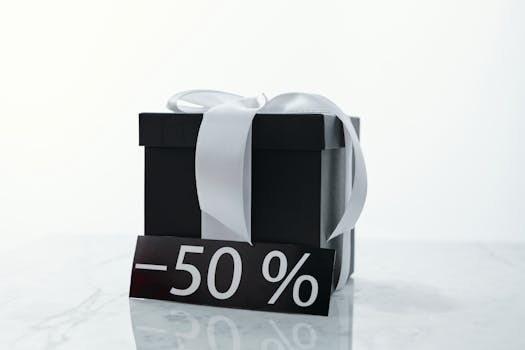 Elegant black gift box tied with a white ribbon, featuring a 50% discount tag.