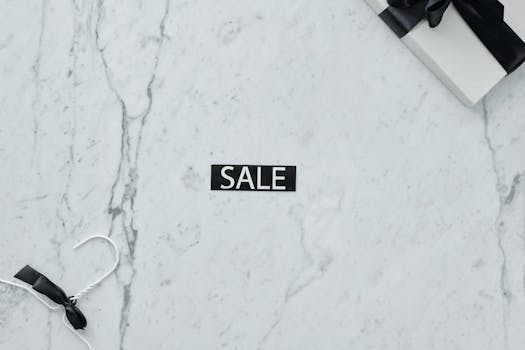 Elegant marble flat lay with sale tag and gift, perfect for retail promotions.