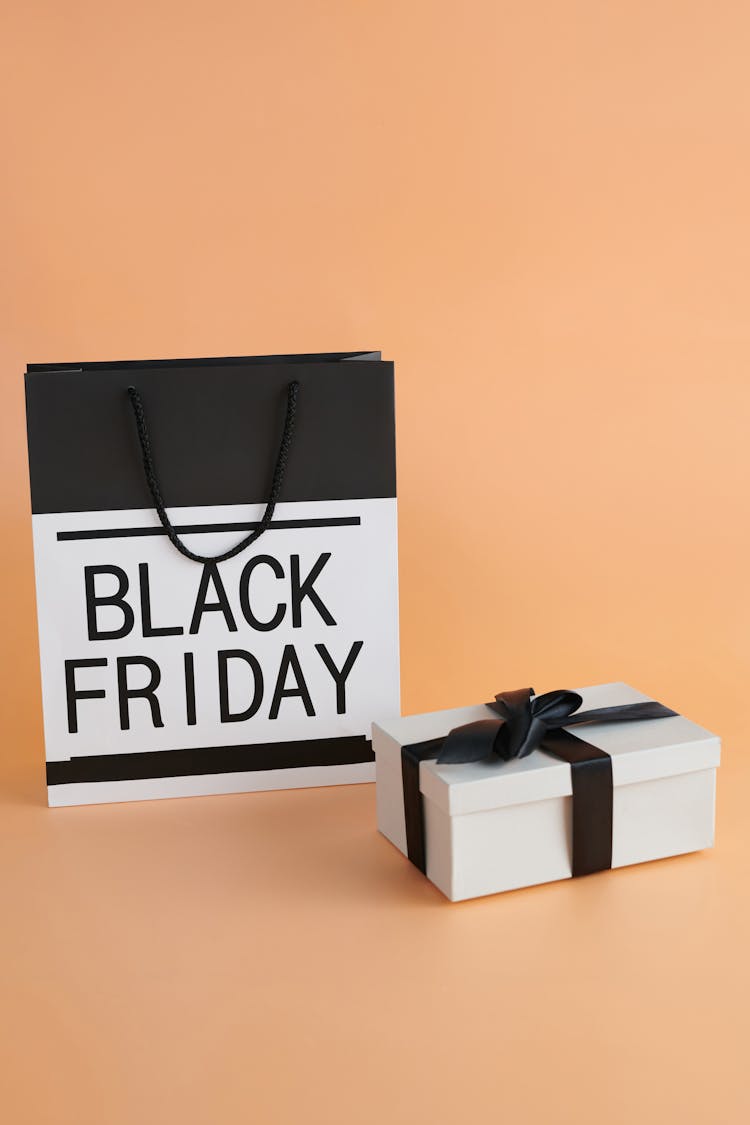 Black And White Paper Bag With Black Friday Text And A Box With Black Ribbon
