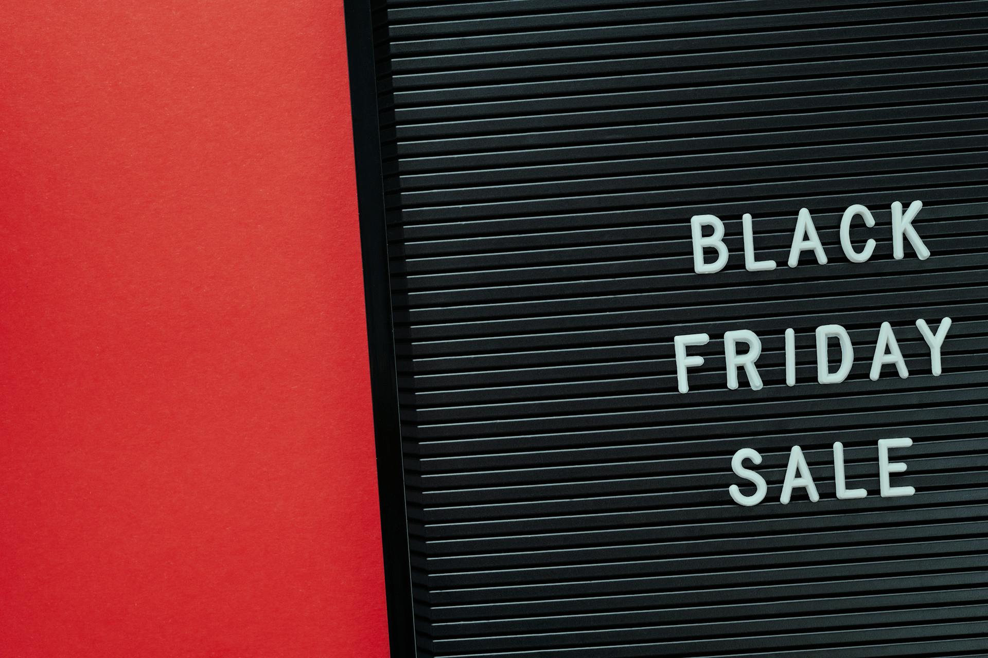 Minimalist Black Friday sale sign on a red background offering copy space for promotional use.