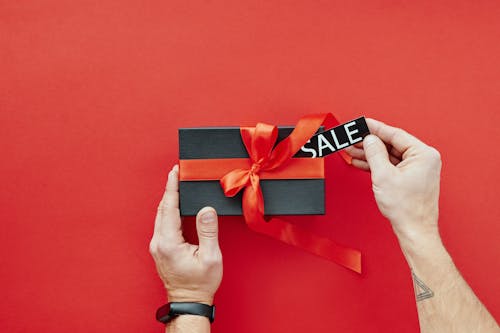 Person Holding Red and Black Box With Red Ribbon