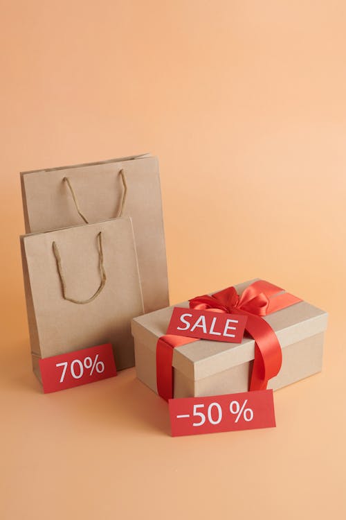 Коричневые бумажные пакеты и картонная коробка со знаком продажи
