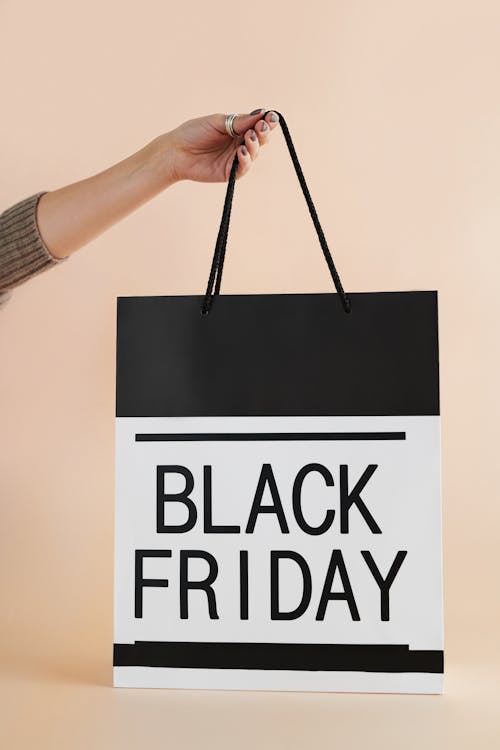 Free Person Holding Black and White Black Friday Paper Bag Stock Photo