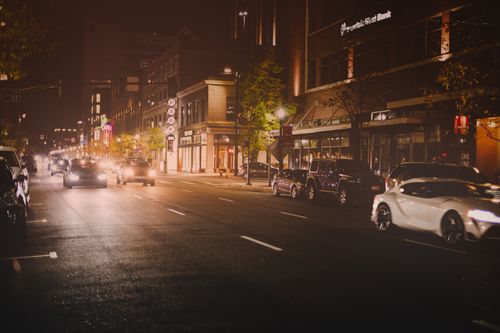 Free Many contemporary automobiles driving on asphalt road near modern buildings of city at night Stock Photo