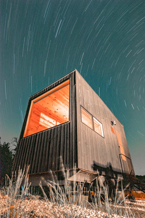 青い空の下で茶色の木造住宅