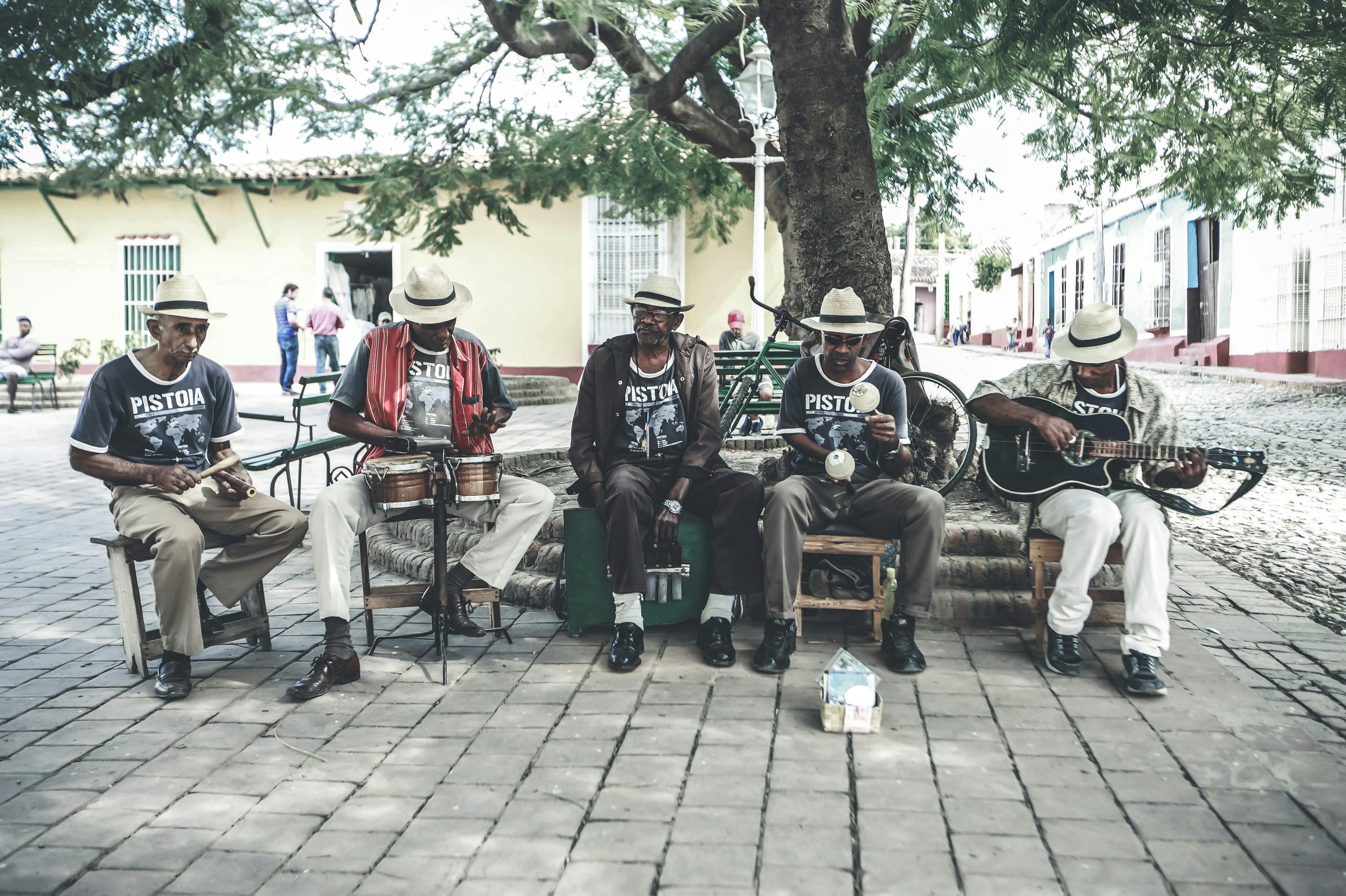 adult ethnic male street band performing song on street