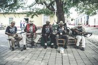 Adult ethnic male street band performing song on street