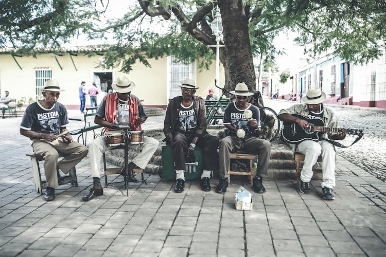 Adult Ethnic Male Street Band Performing Song On Street