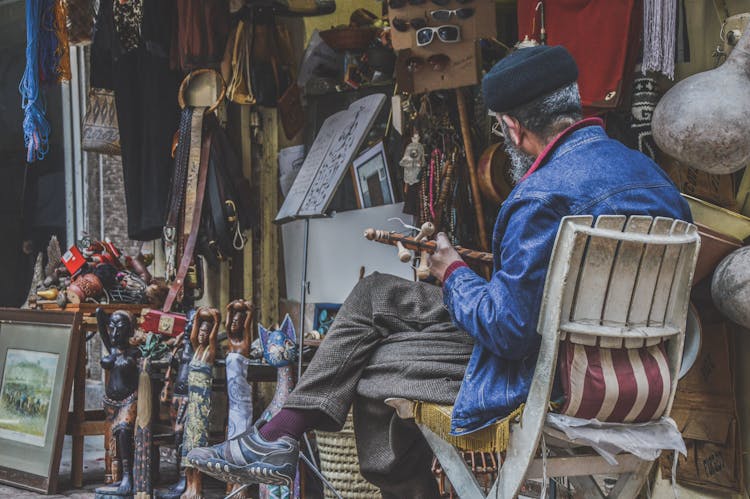 An Elderly Man Sitting On A Chair