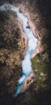 Breathtaking aerial view of a winding river flowing through dense Australian forest.