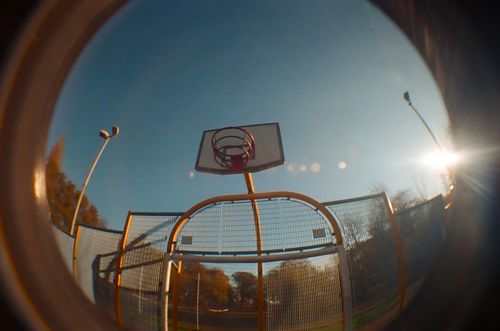 Free Low angle fisheye shot of a basketball hoop against a clear blue sky in daylight. Stock Photo