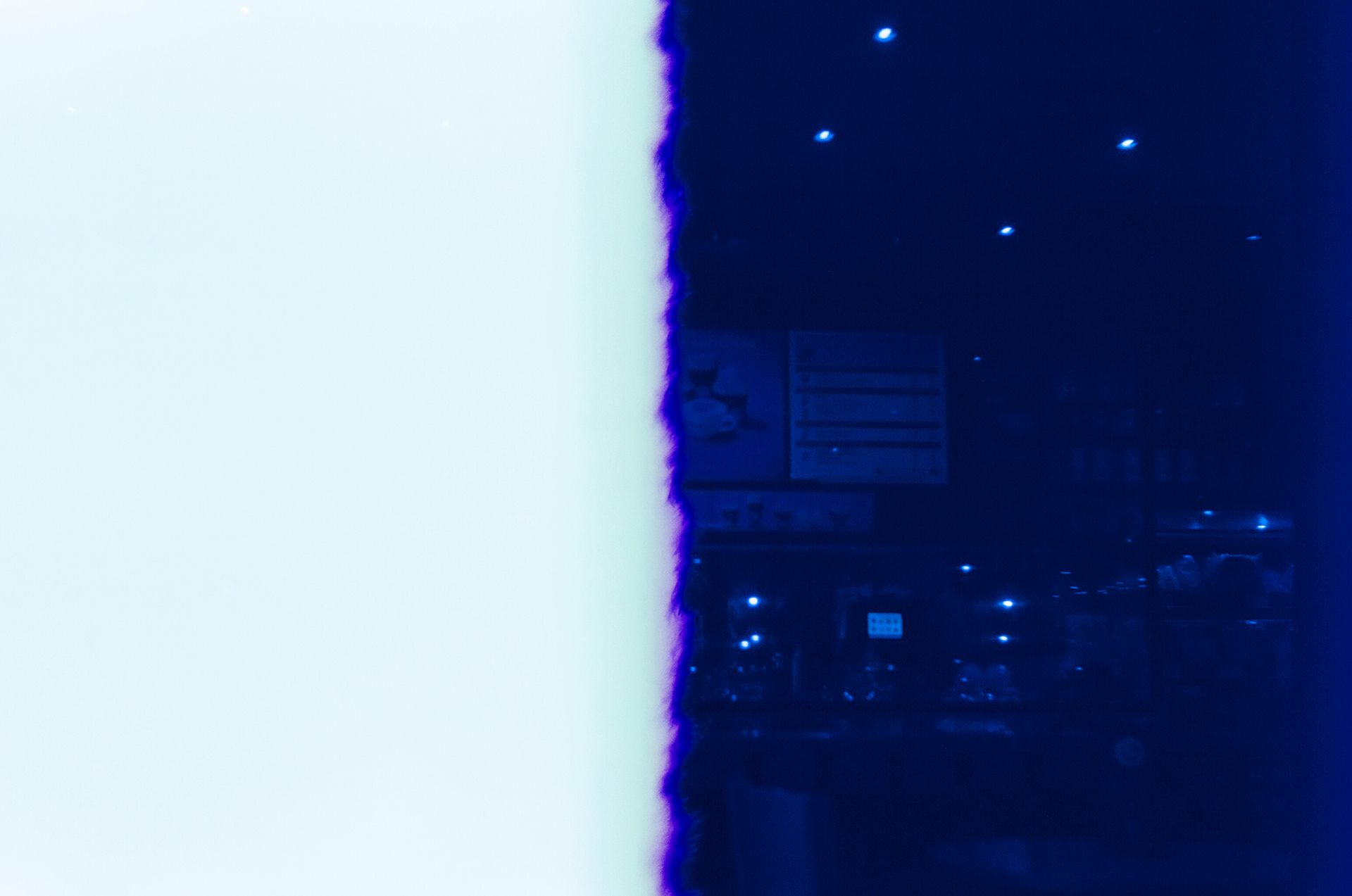 Artistic film photo displaying a dramatic light leak on a dark blue background.