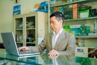 Man in Gray Suit Jacket Using Silver Laptop Computer