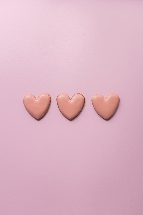 Small heart cookies on pink surface
