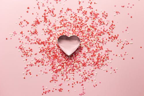 Heart shaped baking tin with small confetti on surface for Valentine day