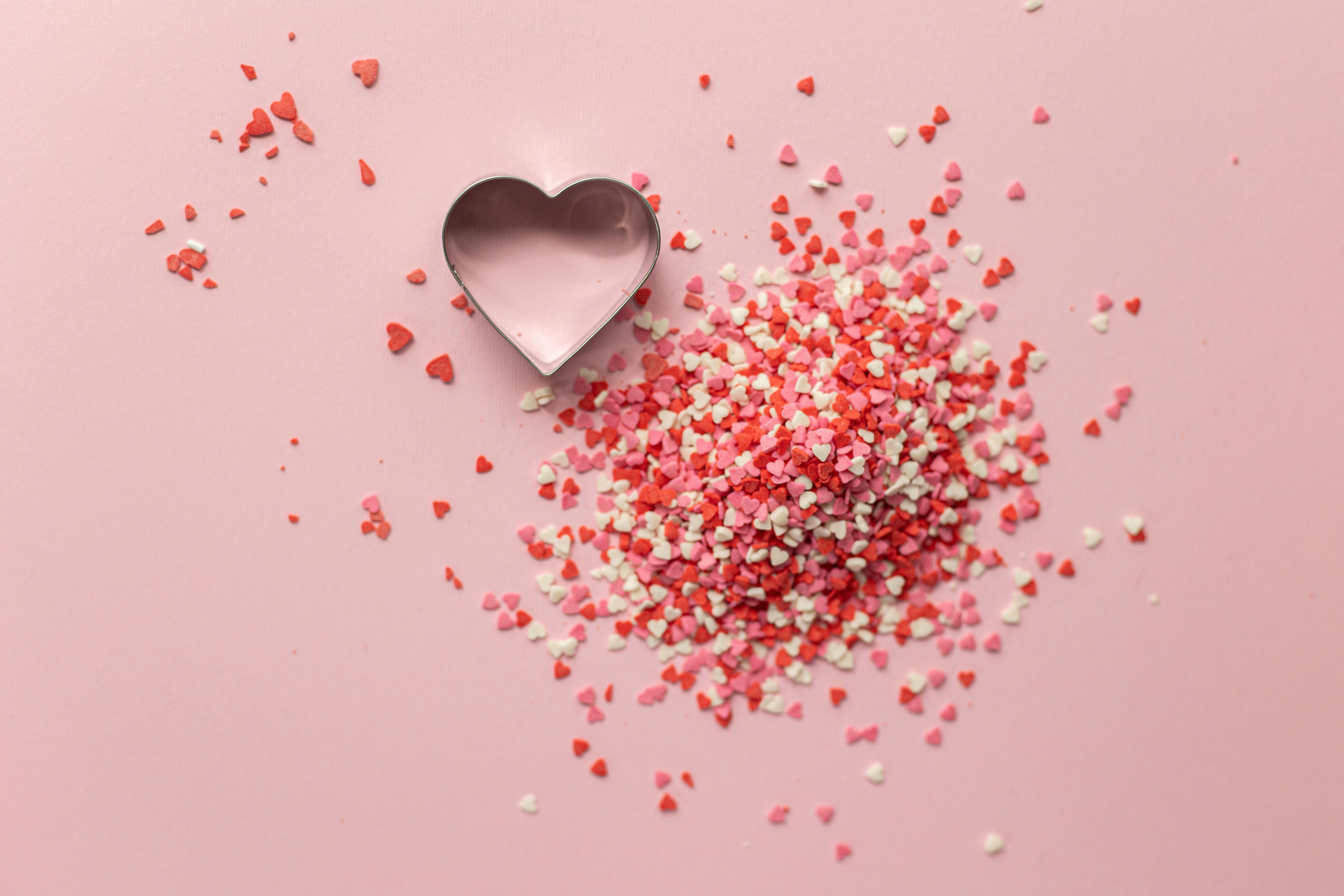 Confetti with heart shape on surface · Free Stock Photo