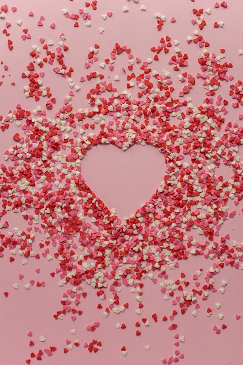 Free Paper hearts scattered on pink background Stock Photo