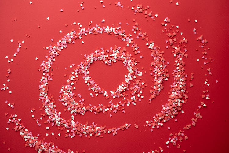 Small Confetti Forming Heart On Red Background