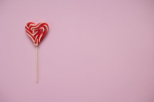 Free Sweet lollipop in form of heart on pink background Stock Photo