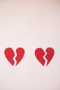 From above of cut parts of red broken hearts on light white background