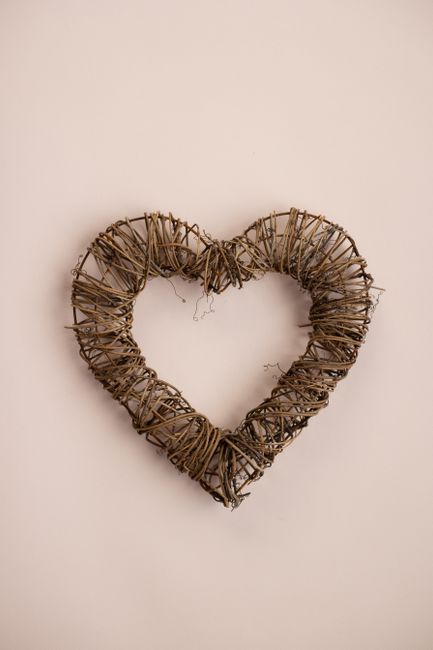 From above of handmade heart from linen rope and wire on pink background