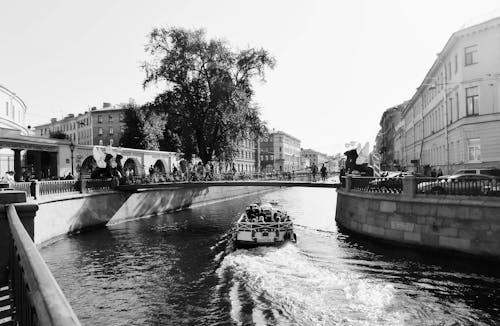 Grayscale Photo of People Riding a Boat on the River