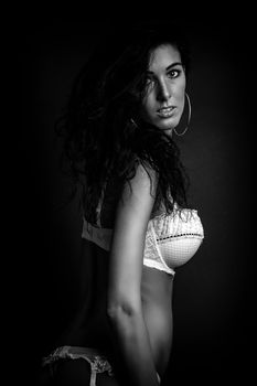 Striking black and white photograph of a woman posing in lingerie, showcasing elegance and style.