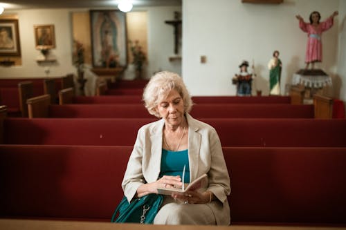 Close-Up Shot of an Elderly Woman Reading a Bible