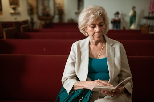 Close-Up Shot of an Elderly Woman Reading a Bible