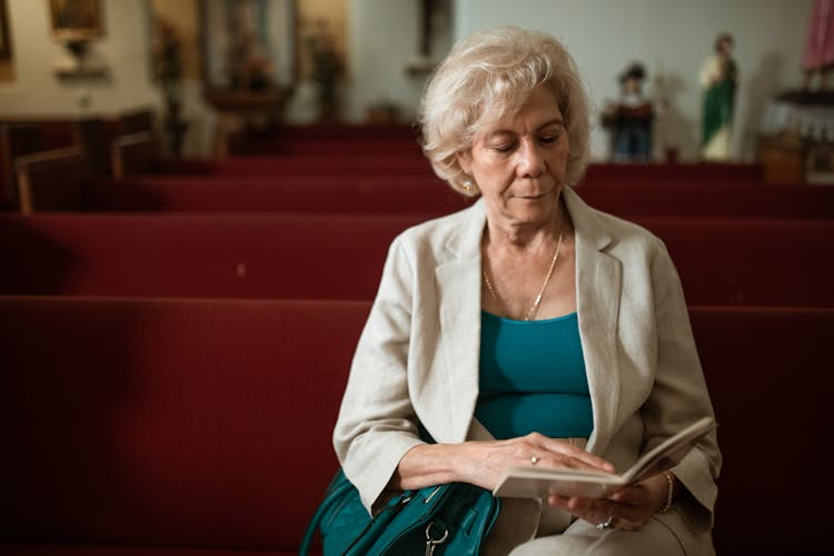 Close-Up Shot Of An Elderly Woman Reading A Bible