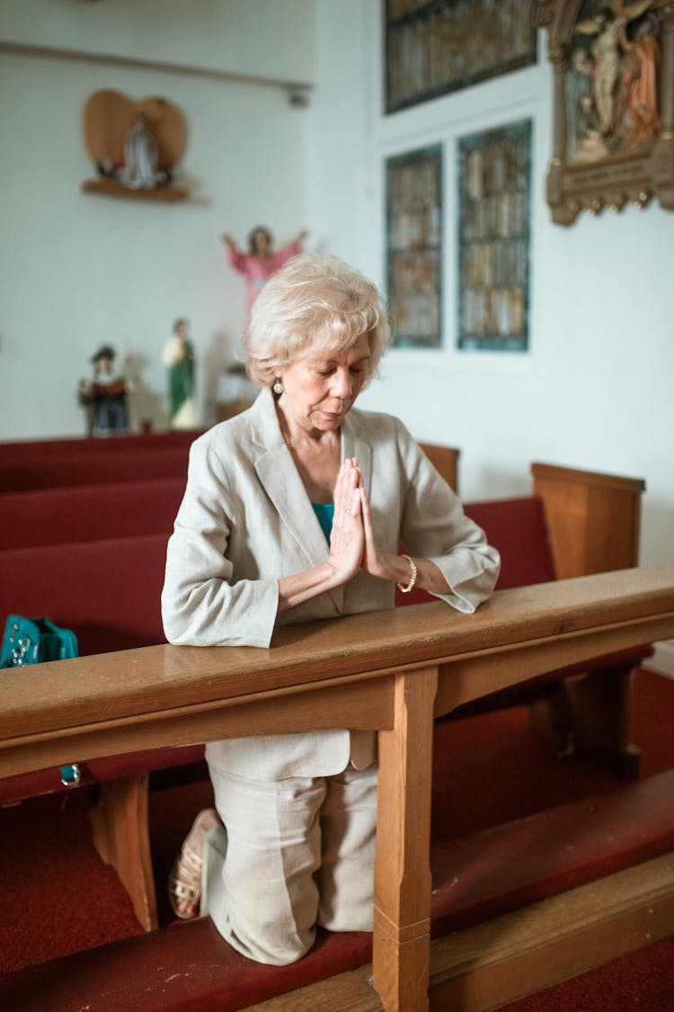 An Elderly Woman Praying In The Church