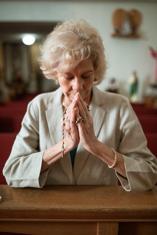 Free Close-Up Shot of an Elderly Woman Praying in the Church Stock Photo