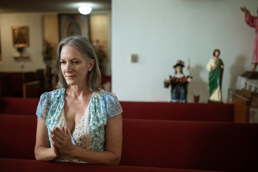 在宁静的教堂里，成熟的女人正在祈祷