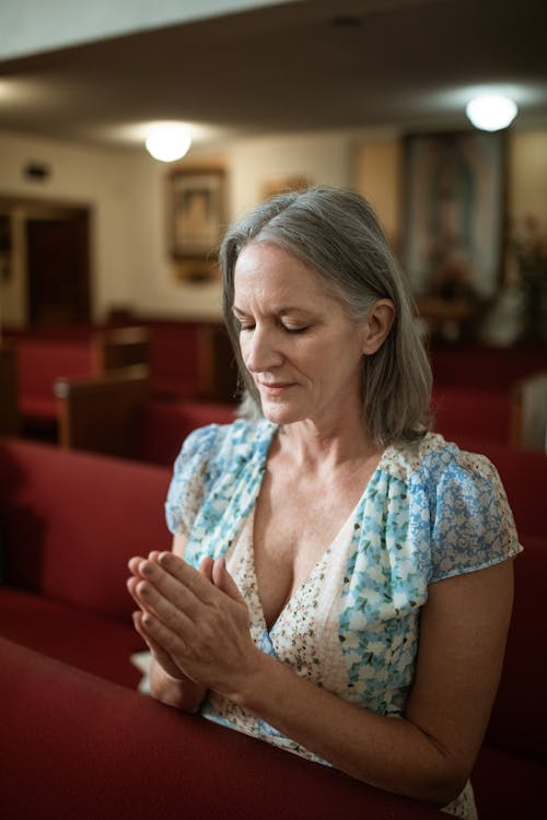 Close-Up Shot of a Woman Praying inside the Church