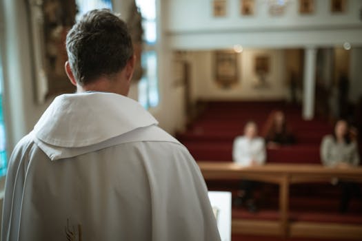 A priest seen from behind delivering a sermon in a church, focusing on spirituality and faith.