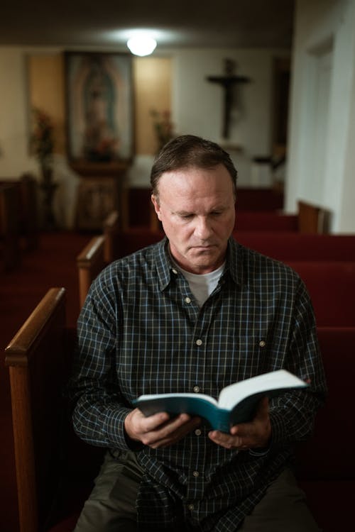Close-Up Shot of a Man Reading a Bible