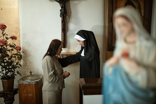 Mujer En Hijab Negro De Pie Junto A Una Mujer En Vestido Blanco