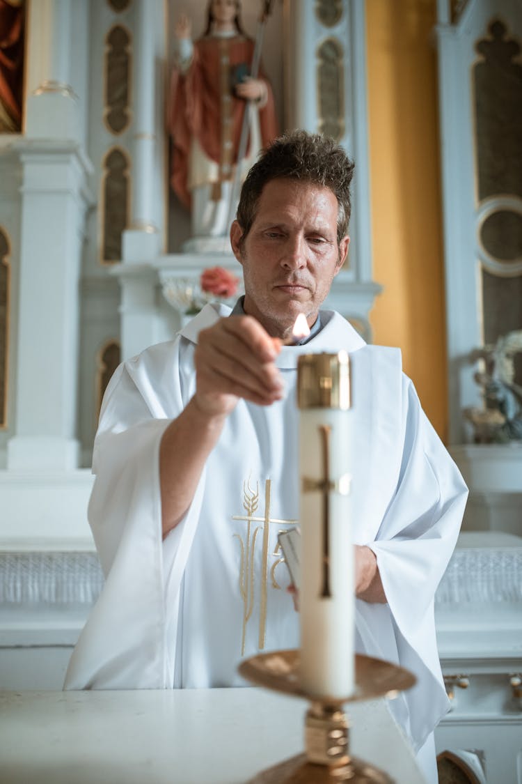 A Priest Lighting A Candle