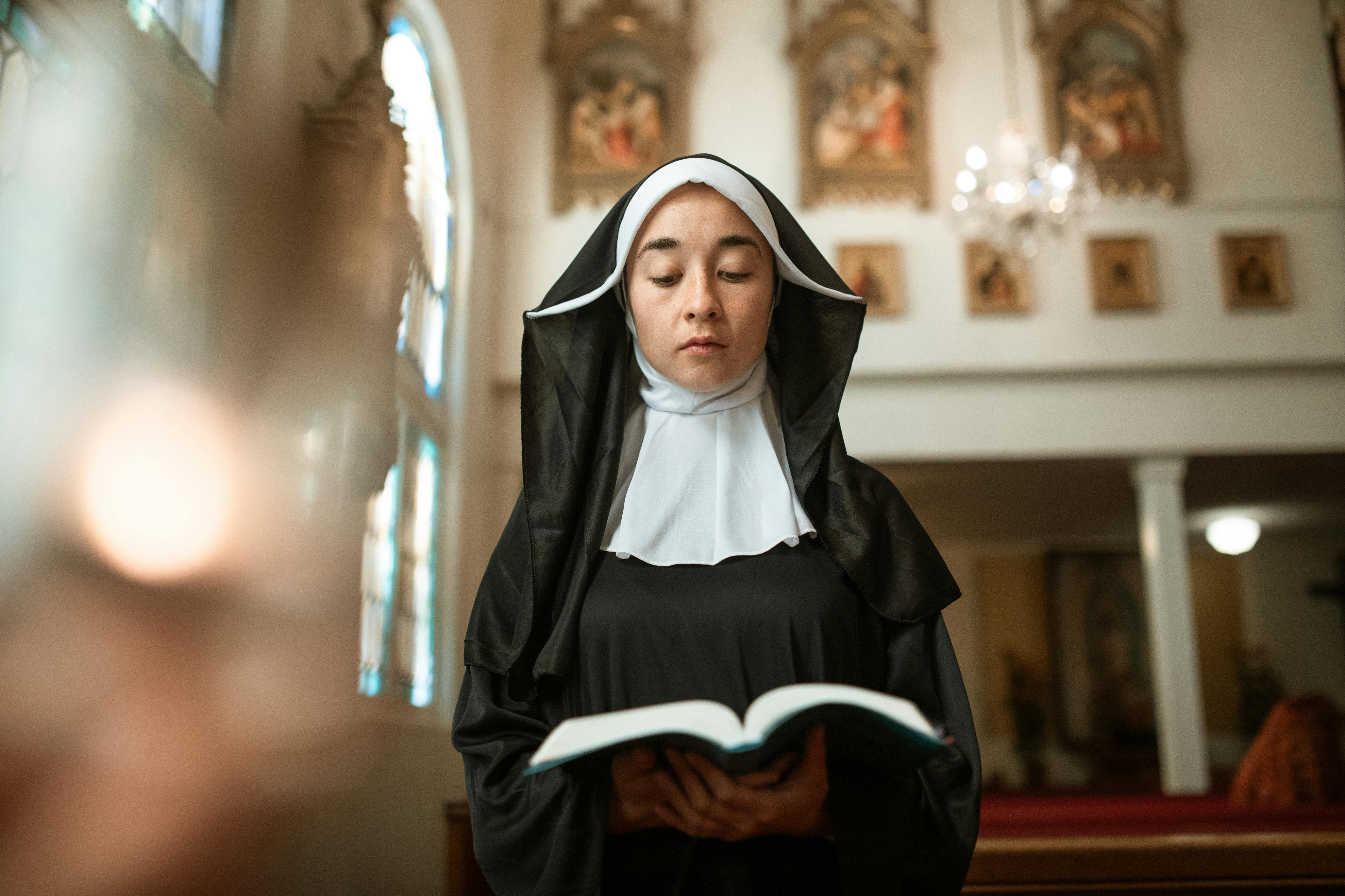 A nun reading the bible. | Photo: Pexels