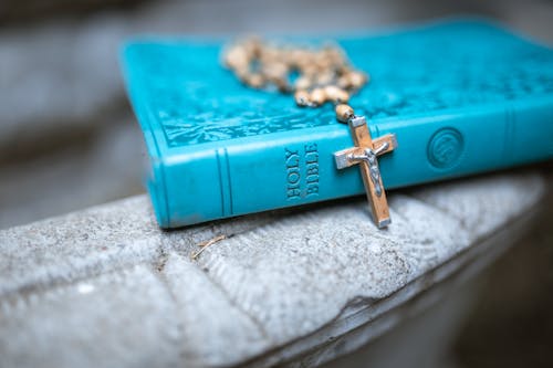 бесплатная Золотой крест кулон на синей книге Стоковое фото