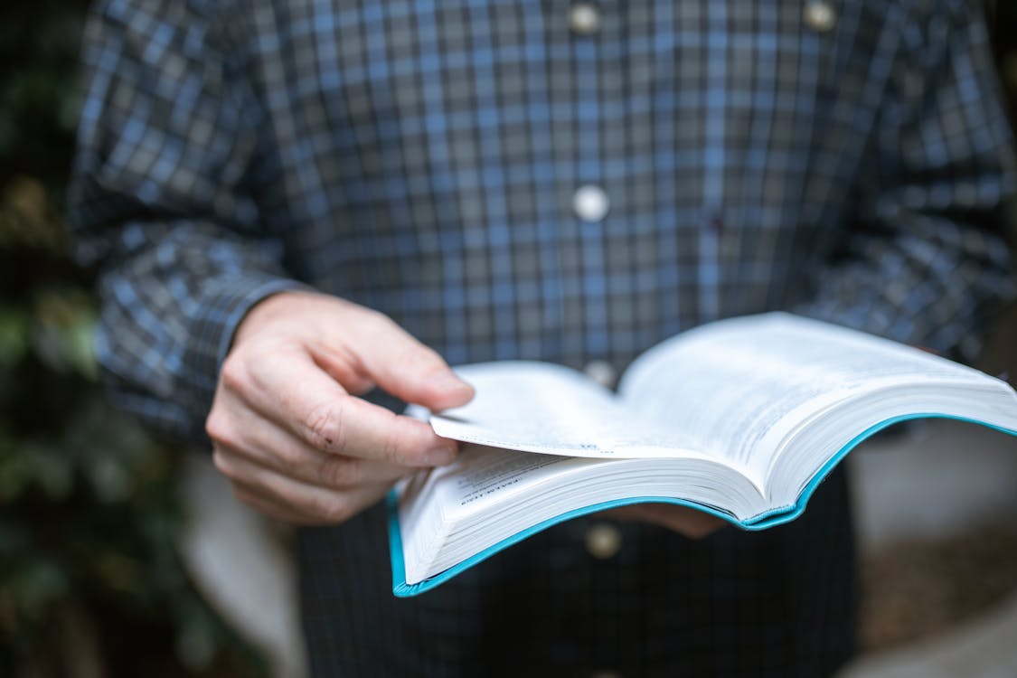 Free Person in Blue and White Plaid Long Sleeve Shirt Holding White Paper Stock Photo