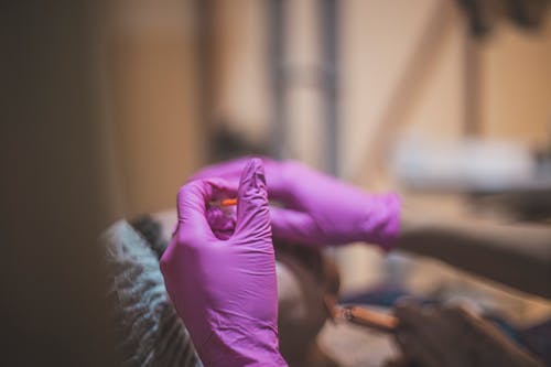 Shallow Focus Photo of Pink Latex Gloves