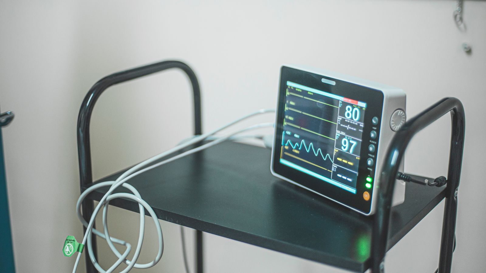 Medical equipment showing heart rate on screen in hospital room.