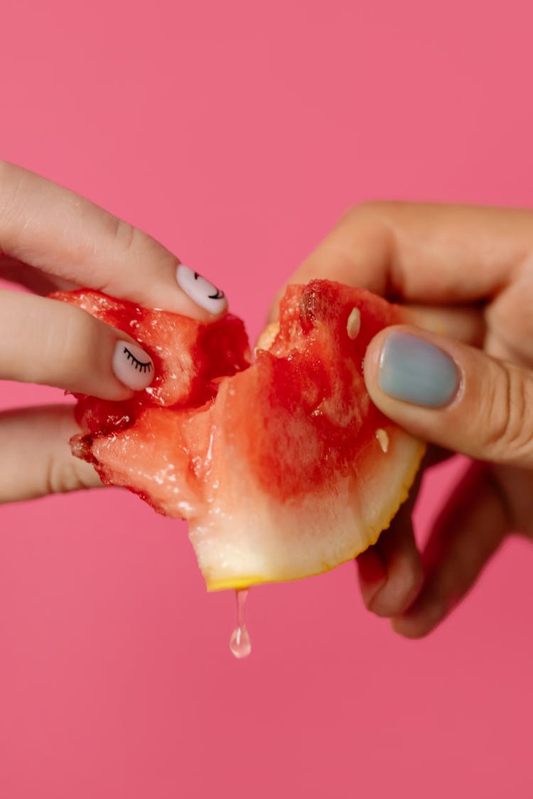 Person Breaking A Slice Of Watermelon