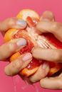 Person Squeezing an Grapefruit